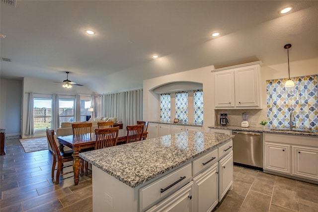 kitchen with white cabinetry, ceiling fan, stainless steel dishwasher, lofted ceiling, and decorative light fixtures