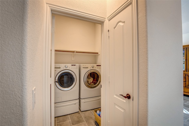 washroom featuring light tile patterned floors and washer and clothes dryer