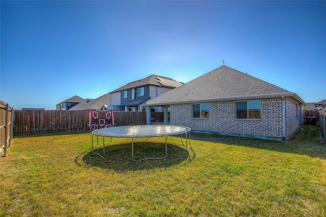 exterior space featuring a trampoline and a yard