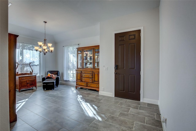 foyer featuring a chandelier and vaulted ceiling