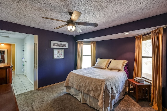 bedroom featuring a textured ceiling, light colored carpet, and ceiling fan