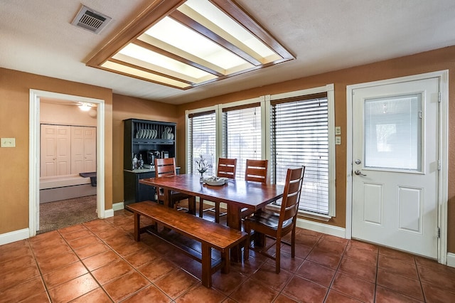 tiled dining room featuring a textured ceiling