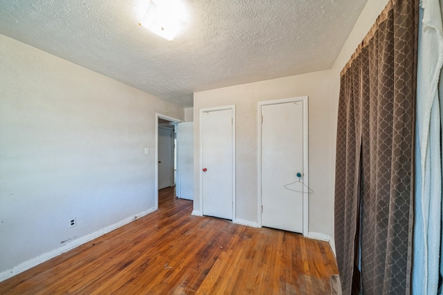 unfurnished bedroom featuring hardwood / wood-style floors and a textured ceiling