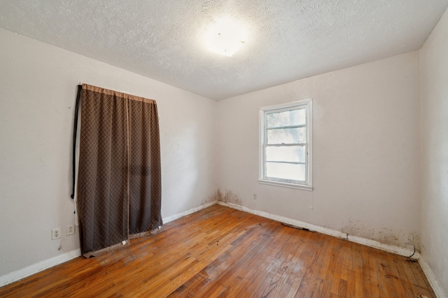 spare room featuring a textured ceiling and wood-type flooring