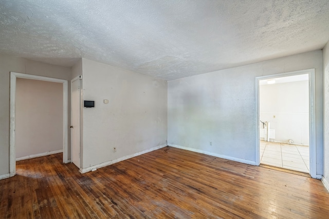 spare room featuring a textured ceiling and hardwood / wood-style flooring