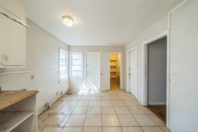 interior space featuring a textured ceiling and light tile patterned floors