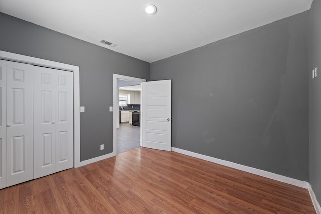 unfurnished bedroom featuring a closet and wood-type flooring