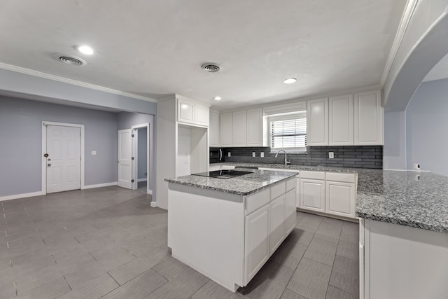 kitchen featuring black appliances, white cabinets, dark stone countertops, and a center island