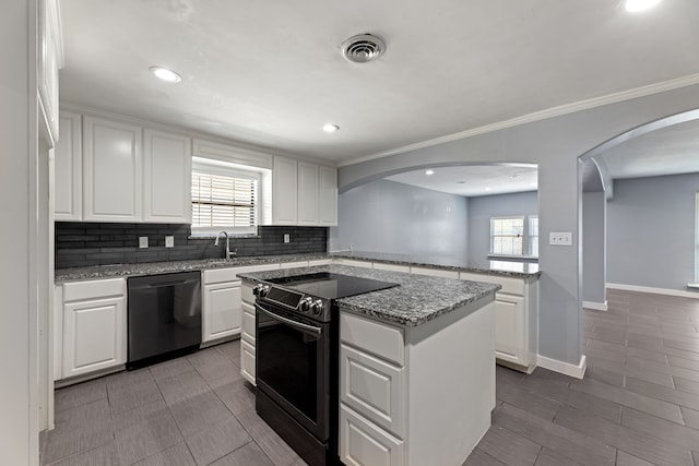 kitchen featuring white cabinets, black appliances, and a wealth of natural light