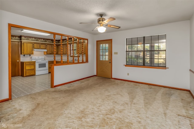 unfurnished living room with a textured ceiling, light colored carpet, and ceiling fan