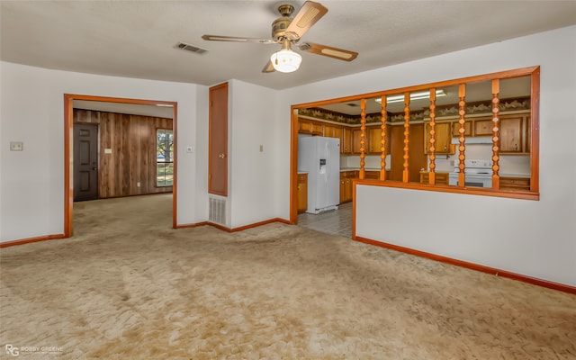 unfurnished living room with light carpet, a textured ceiling, and ceiling fan