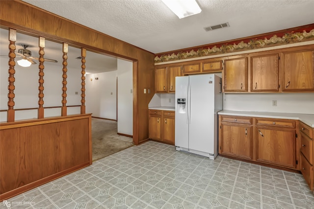 kitchen with ceiling fan, a textured ceiling, and white fridge with ice dispenser