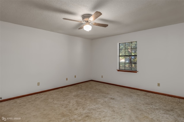 empty room with ceiling fan, carpet, and a textured ceiling