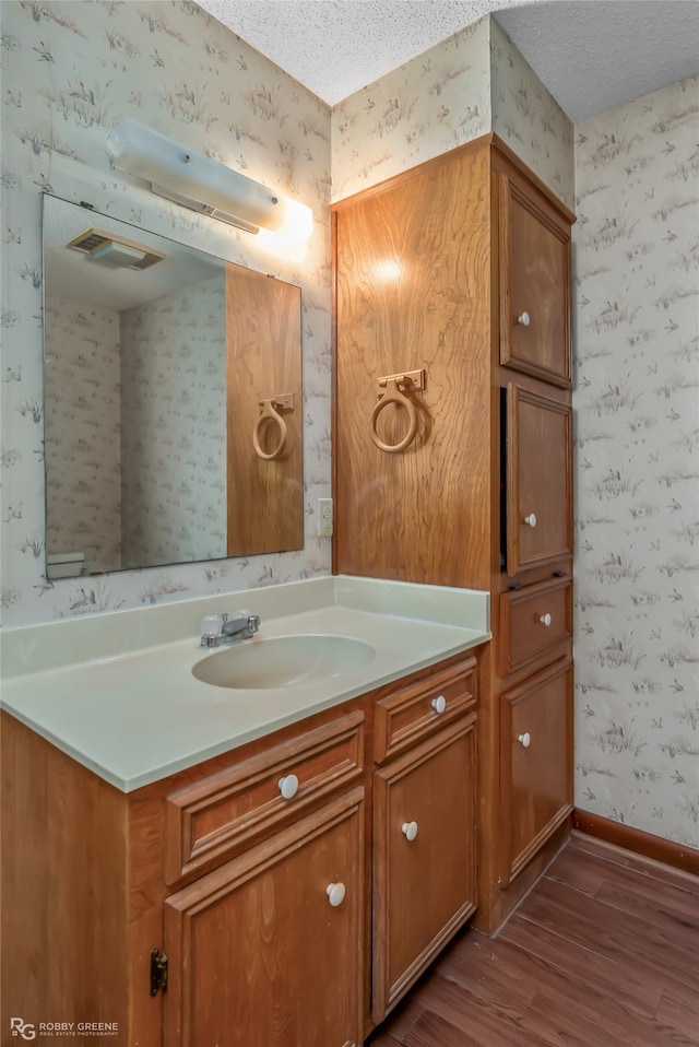 bathroom with vanity, hardwood / wood-style floors, and a textured ceiling