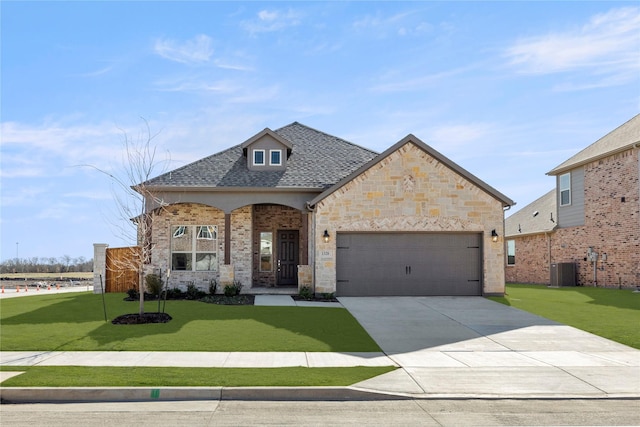 view of front of house with a garage, cooling unit, and a front lawn