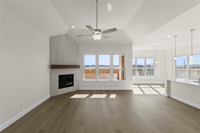 unfurnished living room featuring ceiling fan, lofted ceiling, dark wood-type flooring, and a fireplace