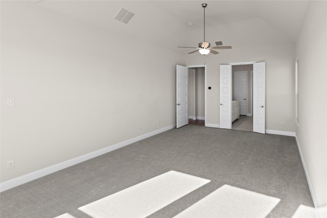 unfurnished bedroom with ceiling fan, connected bathroom, vaulted ceiling, and carpet