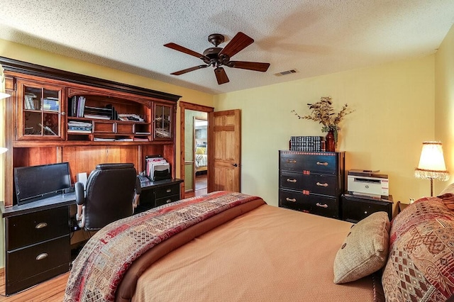 6048 Casey Ct, Fort Worth, TX 76140 - bedroom featuring a ceiling fan, a textured ceiling, visible vents, and wood finished floors