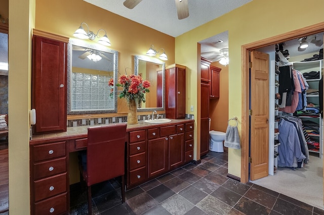 bathroom with vanity, toilet, and a textured ceiling