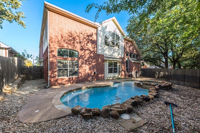 back of house featuring a fenced in pool