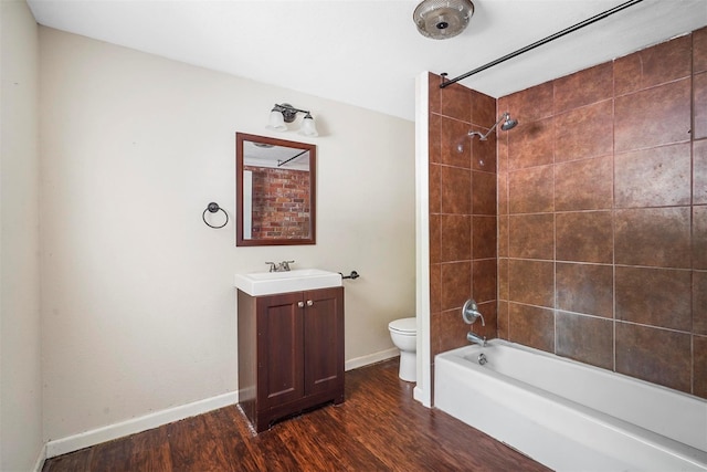 full bathroom featuring vanity, hardwood / wood-style flooring, tiled shower / bath, and toilet