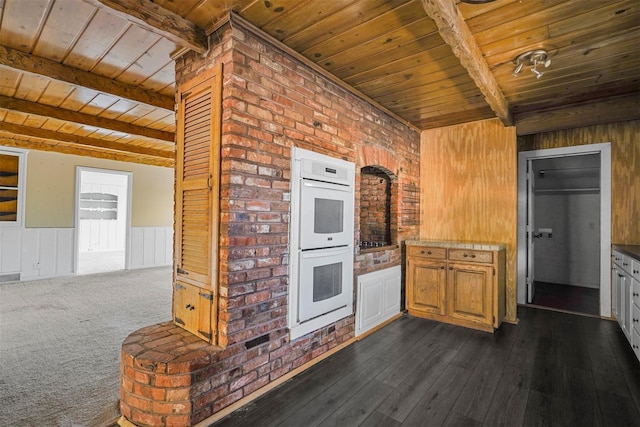 kitchen with dark hardwood / wood-style floors, beam ceiling, white double oven, and wooden ceiling