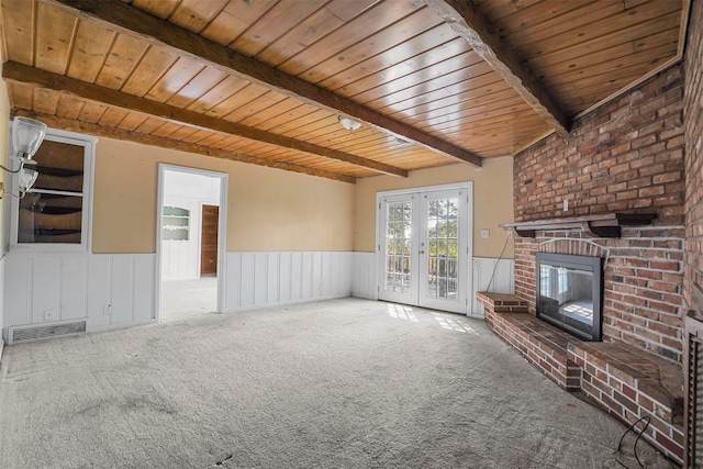 unfurnished living room featuring beam ceiling, french doors, and carpet