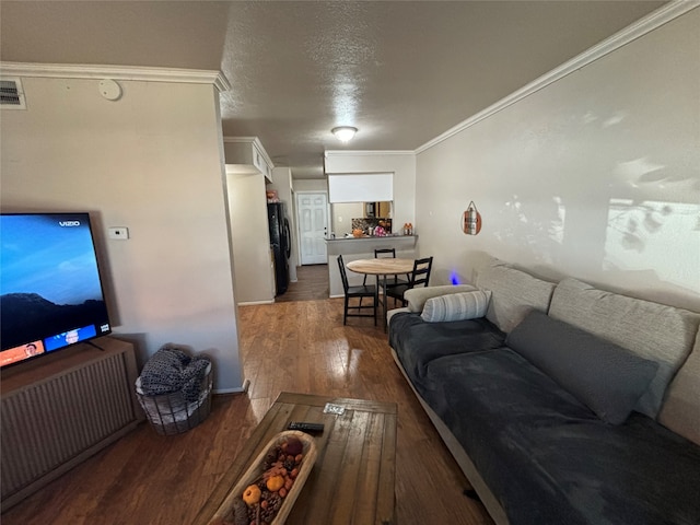 living room with crown molding, a textured ceiling, and dark wood-type flooring