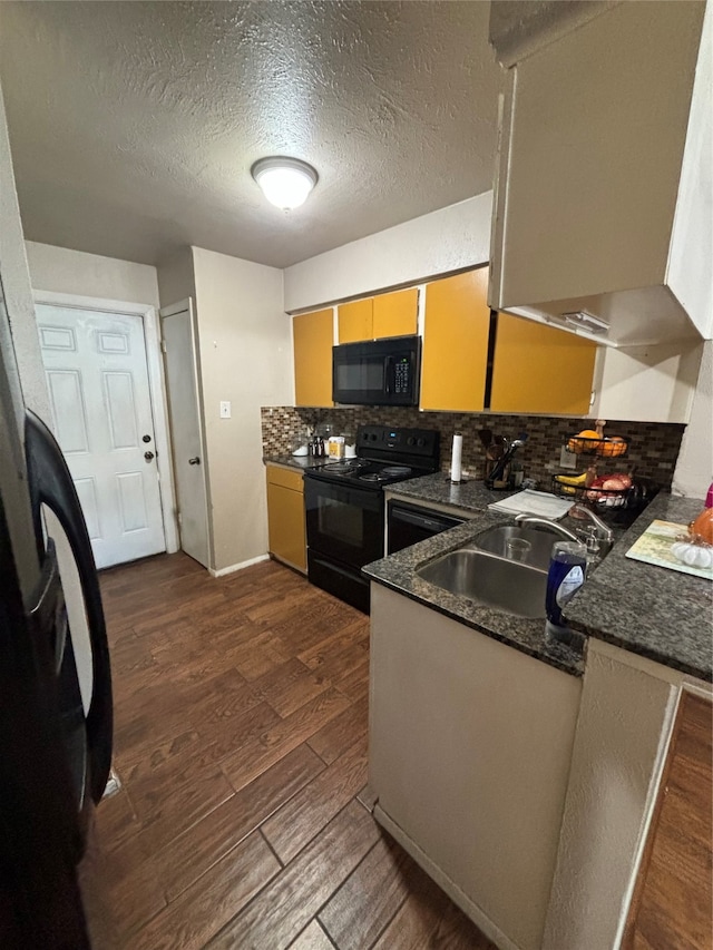 kitchen with tasteful backsplash, black appliances, dark hardwood / wood-style flooring, and a textured ceiling