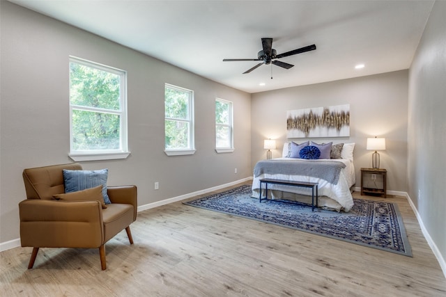 bedroom with multiple windows, light hardwood / wood-style flooring, and ceiling fan