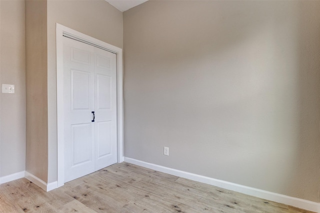 unfurnished bedroom featuring light hardwood / wood-style flooring and a closet