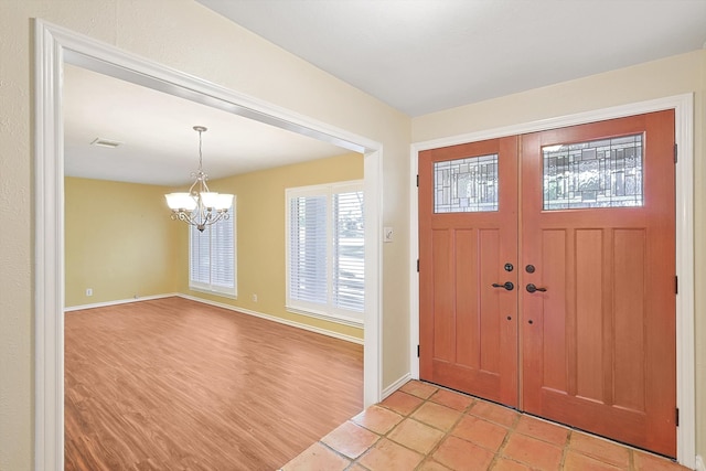 entrance foyer with a notable chandelier and light wood-type flooring