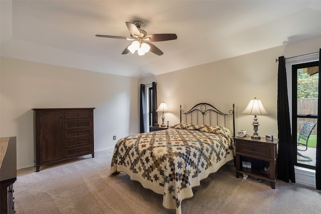 carpeted bedroom with a tray ceiling and ceiling fan