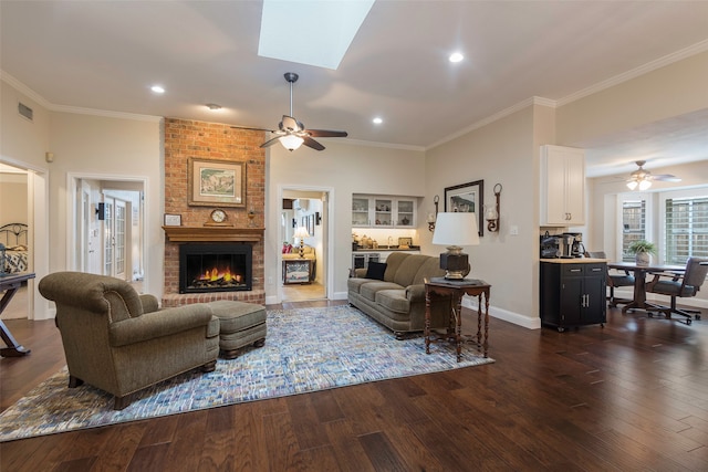 living room featuring a skylight, ceiling fan, a fireplace, and dark hardwood / wood-style floors