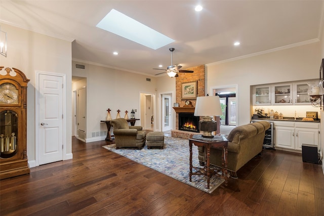 living room with a skylight, sink, dark wood-type flooring, a brick fireplace, and wine cooler