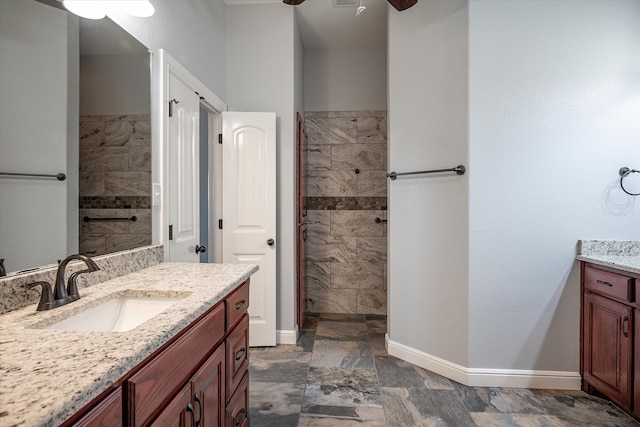 bathroom with vanity, ceiling fan, and a tile shower