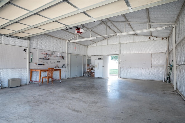 garage featuring a garage door opener, electric panel, and a workshop area