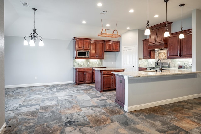 kitchen with pendant lighting, sink, stainless steel microwave, light stone counters, and tasteful backsplash