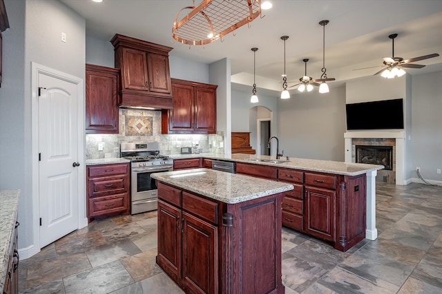 kitchen with sink, tasteful backsplash, a kitchen island, pendant lighting, and stainless steel appliances