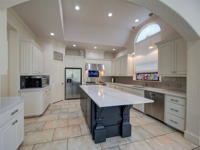 kitchen featuring appliances with stainless steel finishes, lofted ceiling, decorative backsplash, and white cabinets