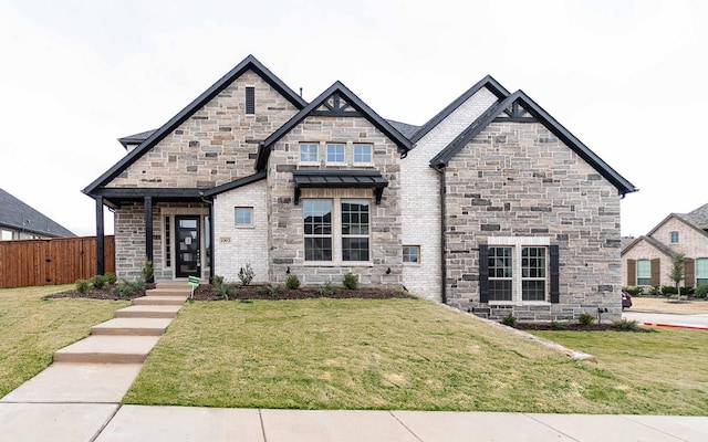 french country home with a front lawn, fence, and brick siding