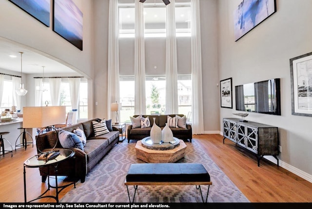 living room with hardwood / wood-style floors, a high ceiling, and ceiling fan