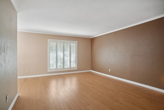 unfurnished room featuring a textured ceiling, light hardwood / wood-style flooring, and crown molding