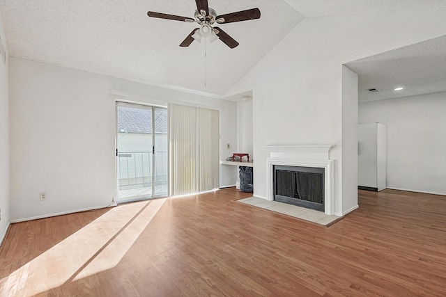 unfurnished living room featuring ceiling fan, a textured ceiling, light wood-type flooring, and vaulted ceiling