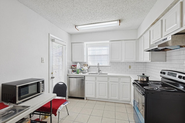 kitchen featuring sink, appliances with stainless steel finishes, a textured ceiling, white cabinets, and decorative backsplash