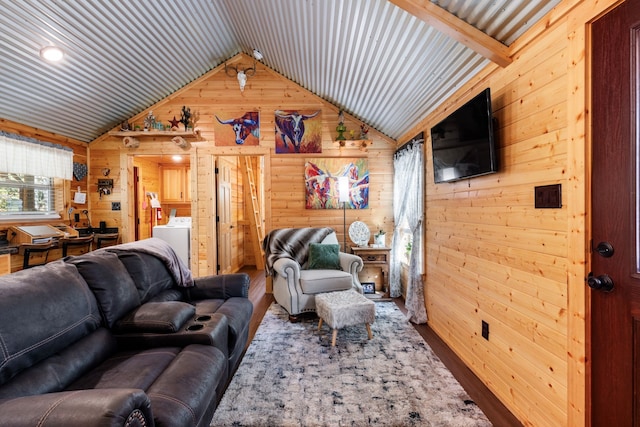 living room featuring washer / dryer, wood walls, and vaulted ceiling