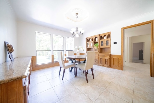 dining area featuring a notable chandelier, crown molding, and light tile patterned floors