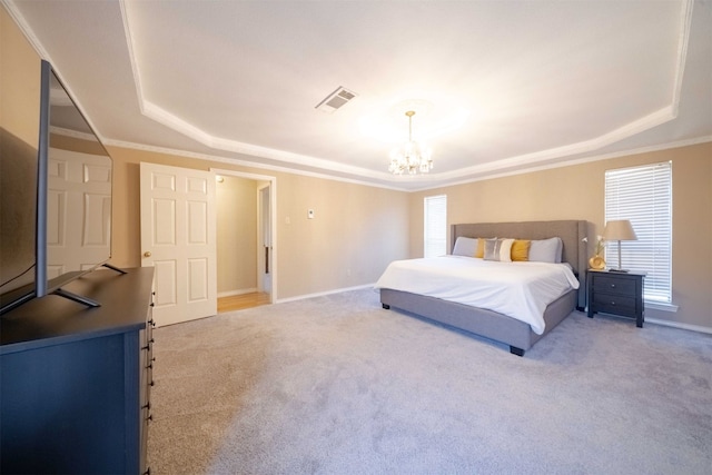 carpeted bedroom with a notable chandelier, ornamental molding, and a tray ceiling