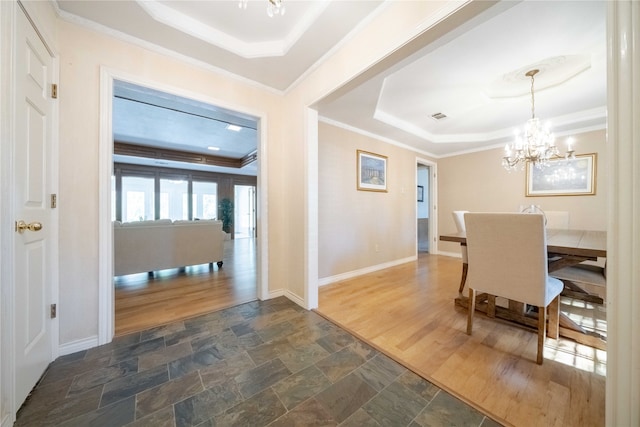 dining area with ornamental molding, a chandelier, a tray ceiling, and dark hardwood / wood-style flooring