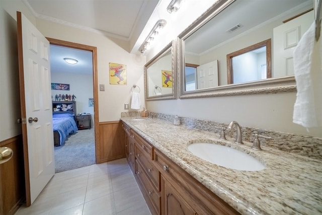 bathroom featuring vanity, crown molding, wooden walls, and tile patterned floors